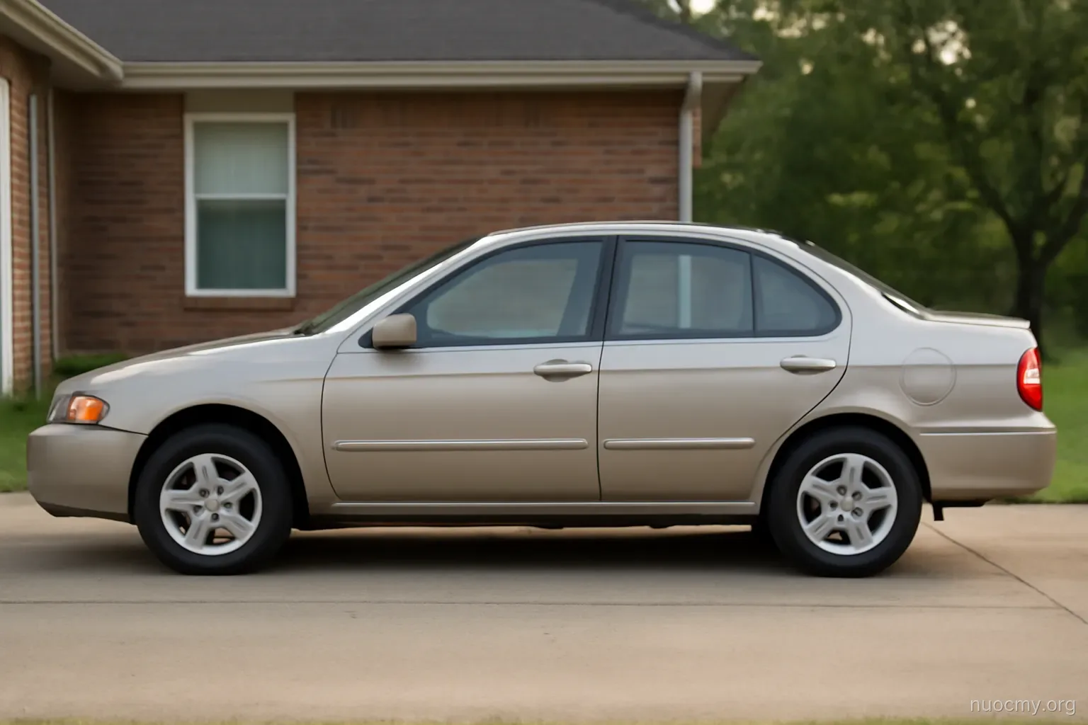 a car parked in a driveway with its hood closed, seen from the side in flat afternoon light